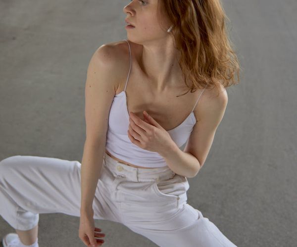 Woman performing a graceful yoga flow sequence in a sunlit room.